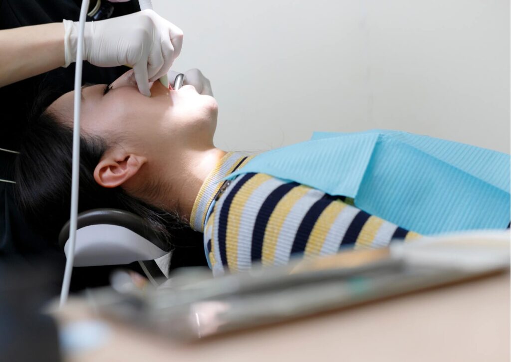 Patient receiving a dental examination while discussing oral health concerns that may be associated with Ozempic use, such as dry mouth, tooth sensitivity, or increased cavity risk.