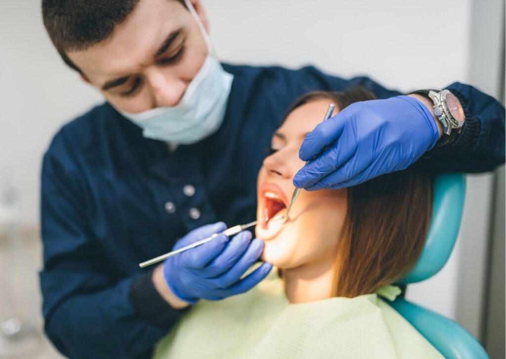 Dentist examining a patient's teeth for signs of tooth decay, including visible cavities, discoloration, and areas of enamel damage that may require treatment.