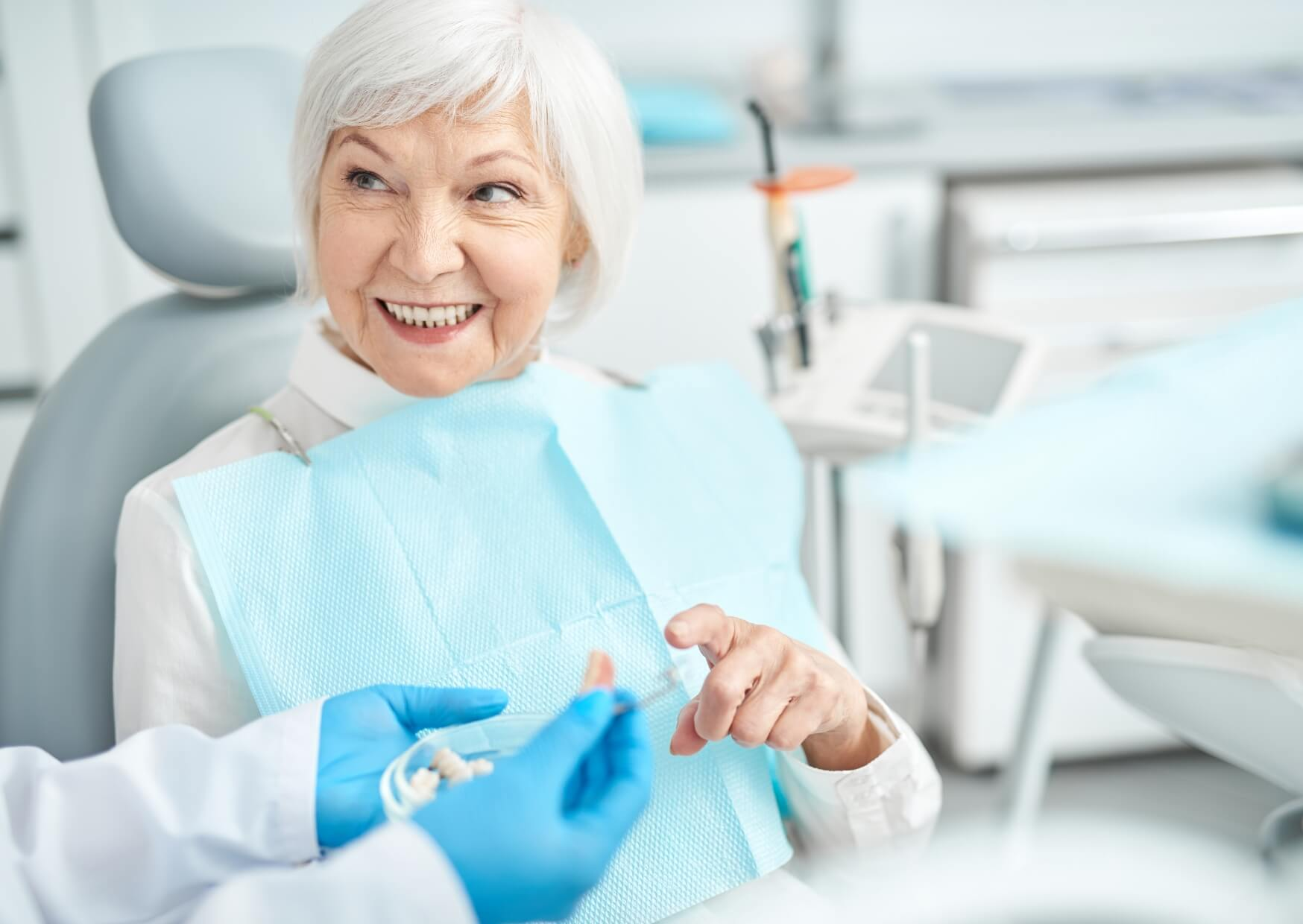 Older adult discussing tooth replacement options with a dentist, showing it is not necessarily too late to get dental implants.