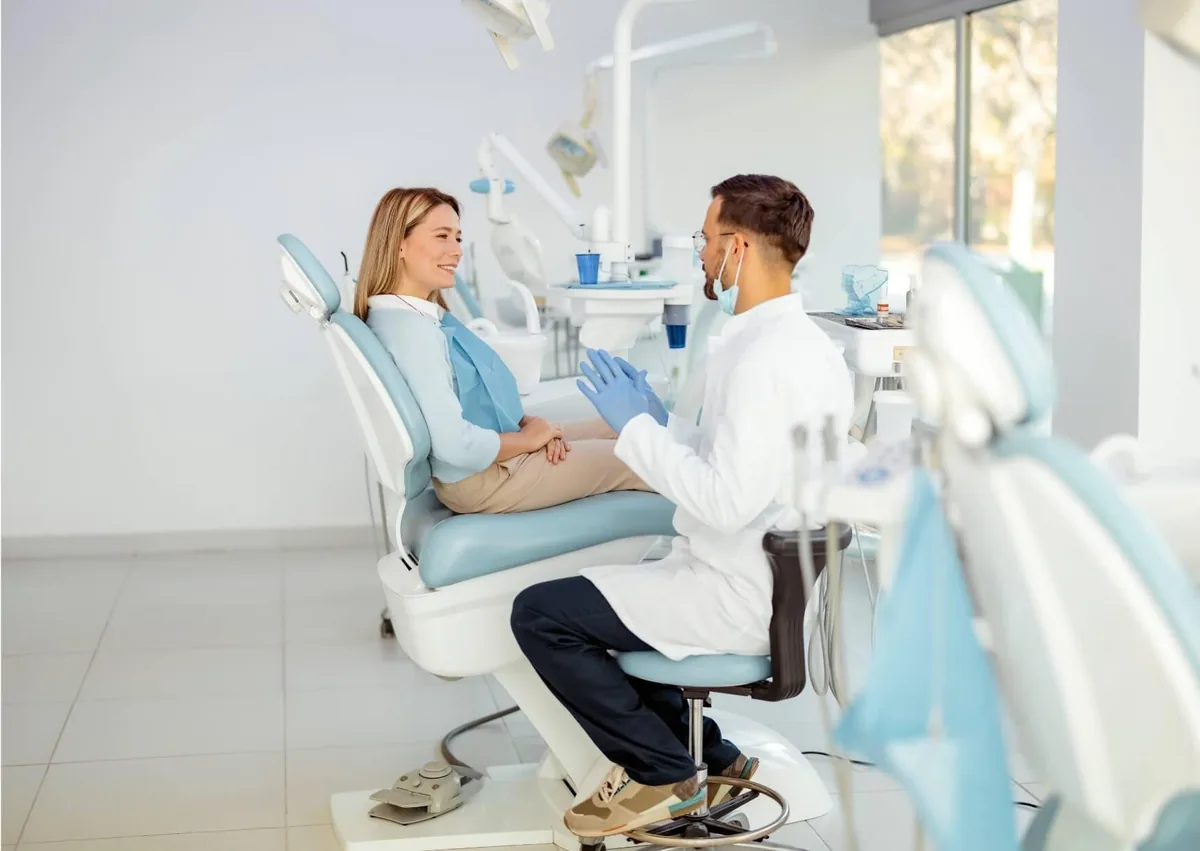 Dentist discussing tooth bonding treatment and cost with a patient during a cosmetic dentistry consultation.