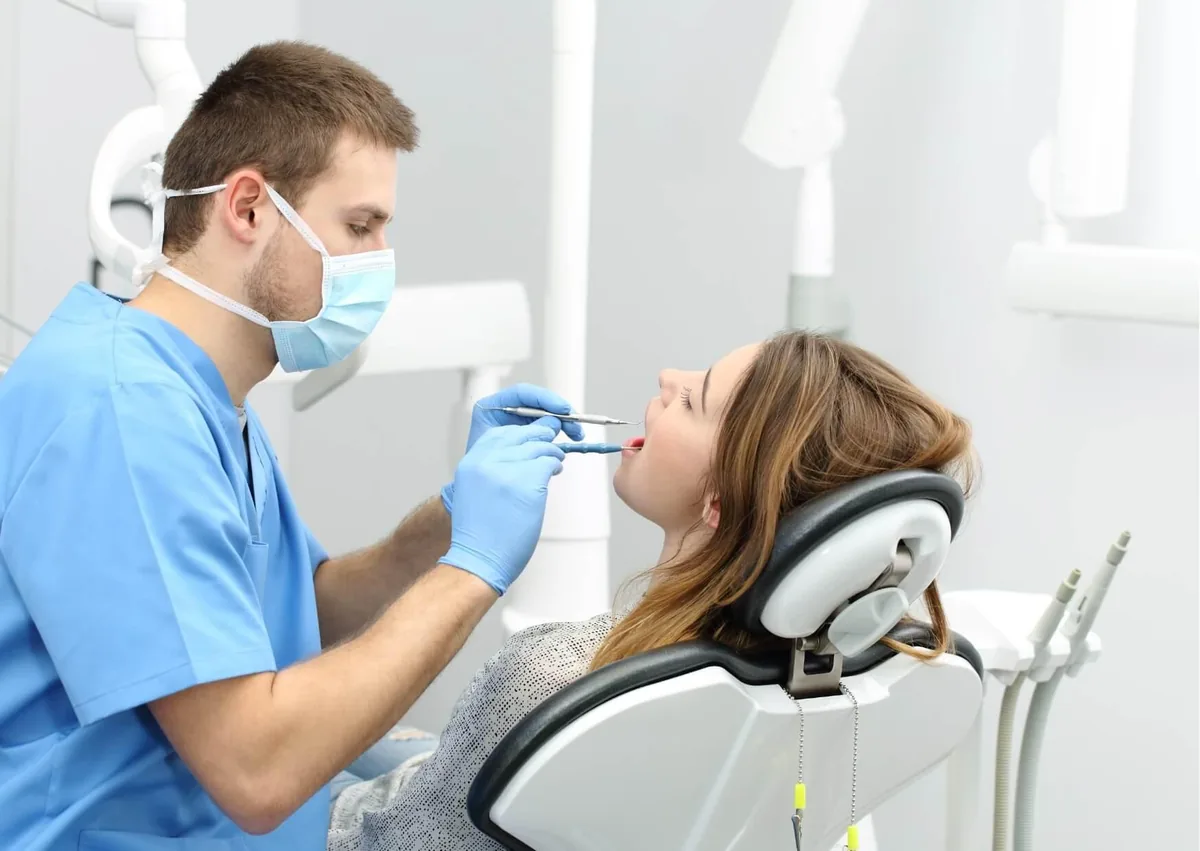Dentist examining a patient’s mouth for signs and oral health effects of dry mouth.